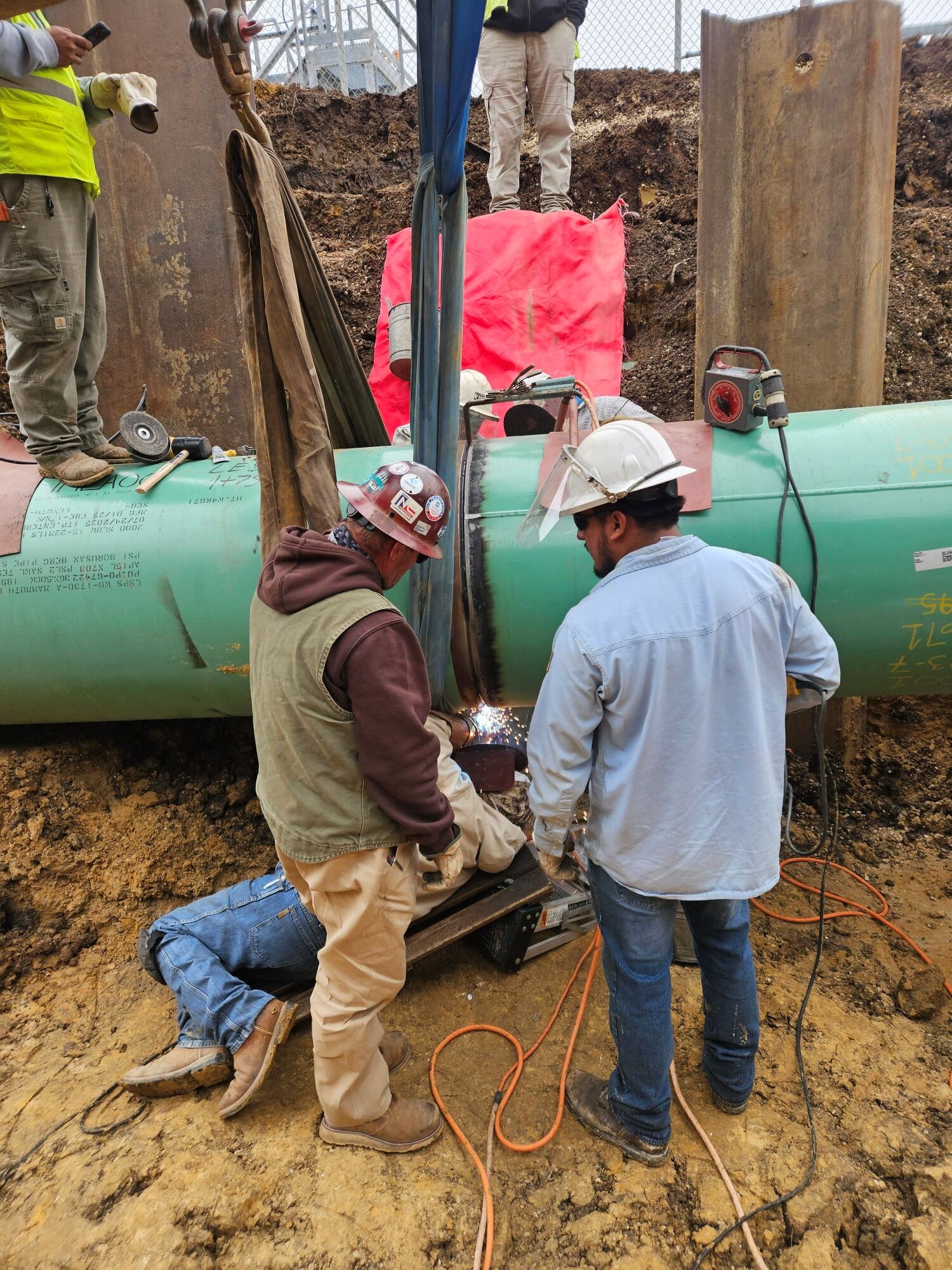 Crew welding a tie-in on a 36-inch internally lined brine pipeline