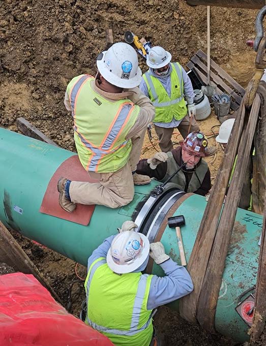 Crew installing a FlexSleeve at a 36-inch pipeline tie-in